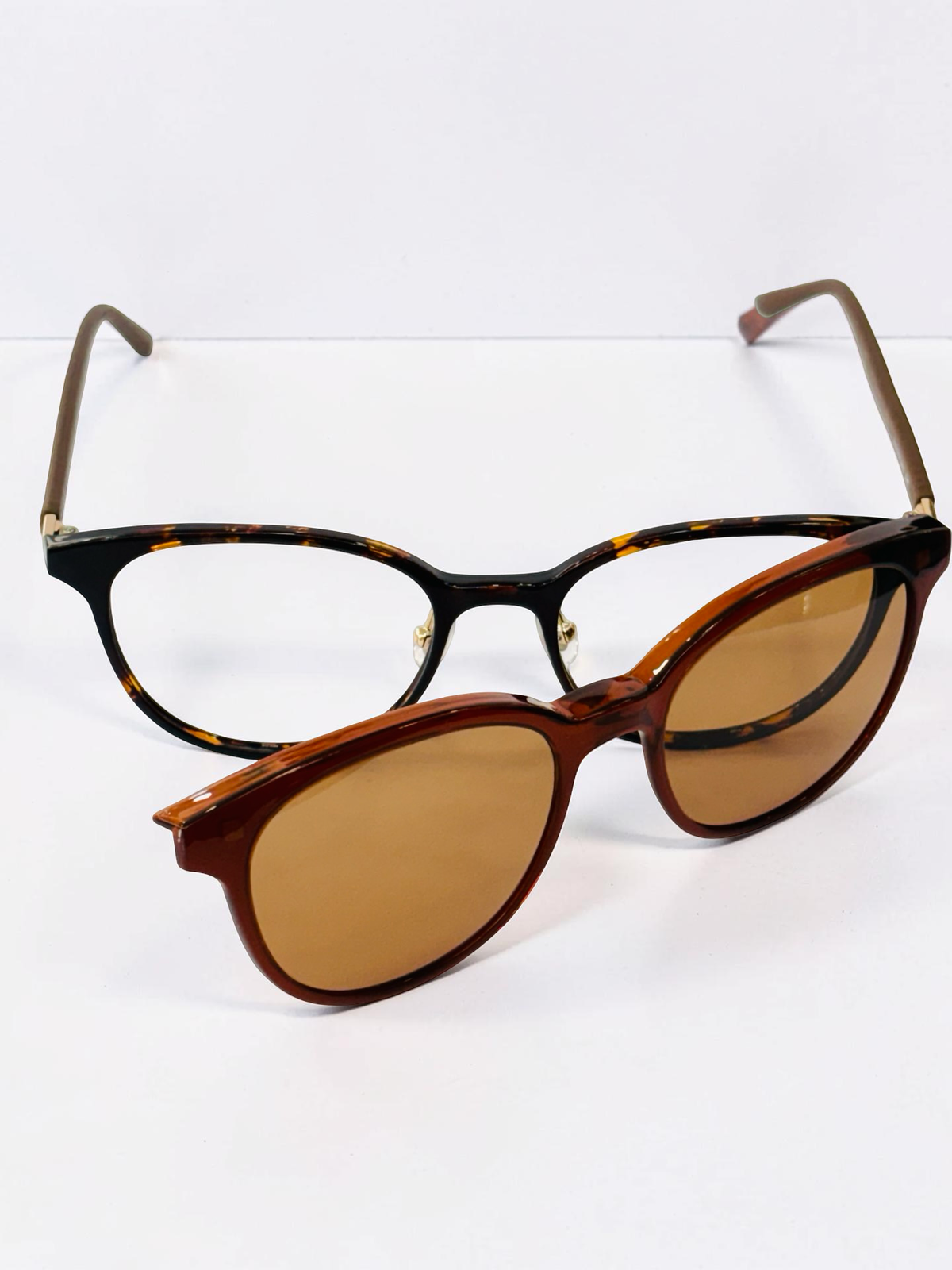Black and tortoiseshell cat-eye frame with brown clip-on attached