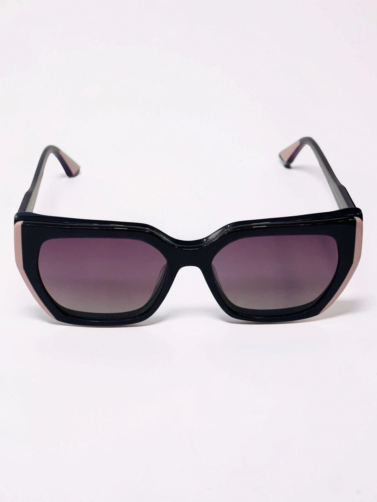 Angled view of black optical frame with blush-pink temple tips