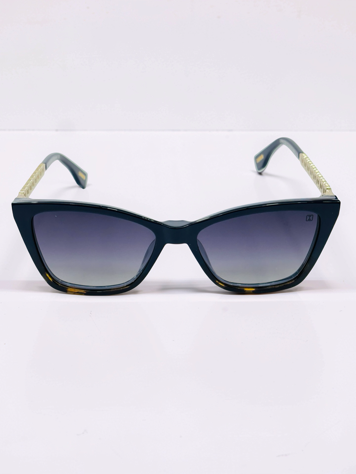 Front view of polarized dark gradient sun clip attached to blue cat-eye frame
