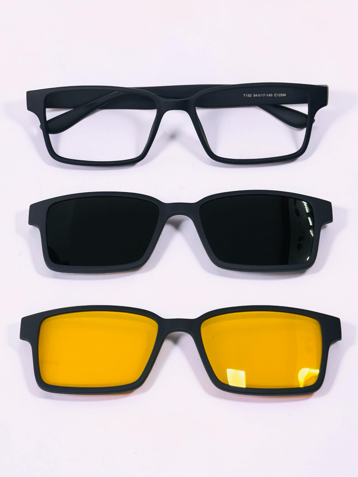 Black optical frame with yellow clip-on lens and dark clip-on lens displayed