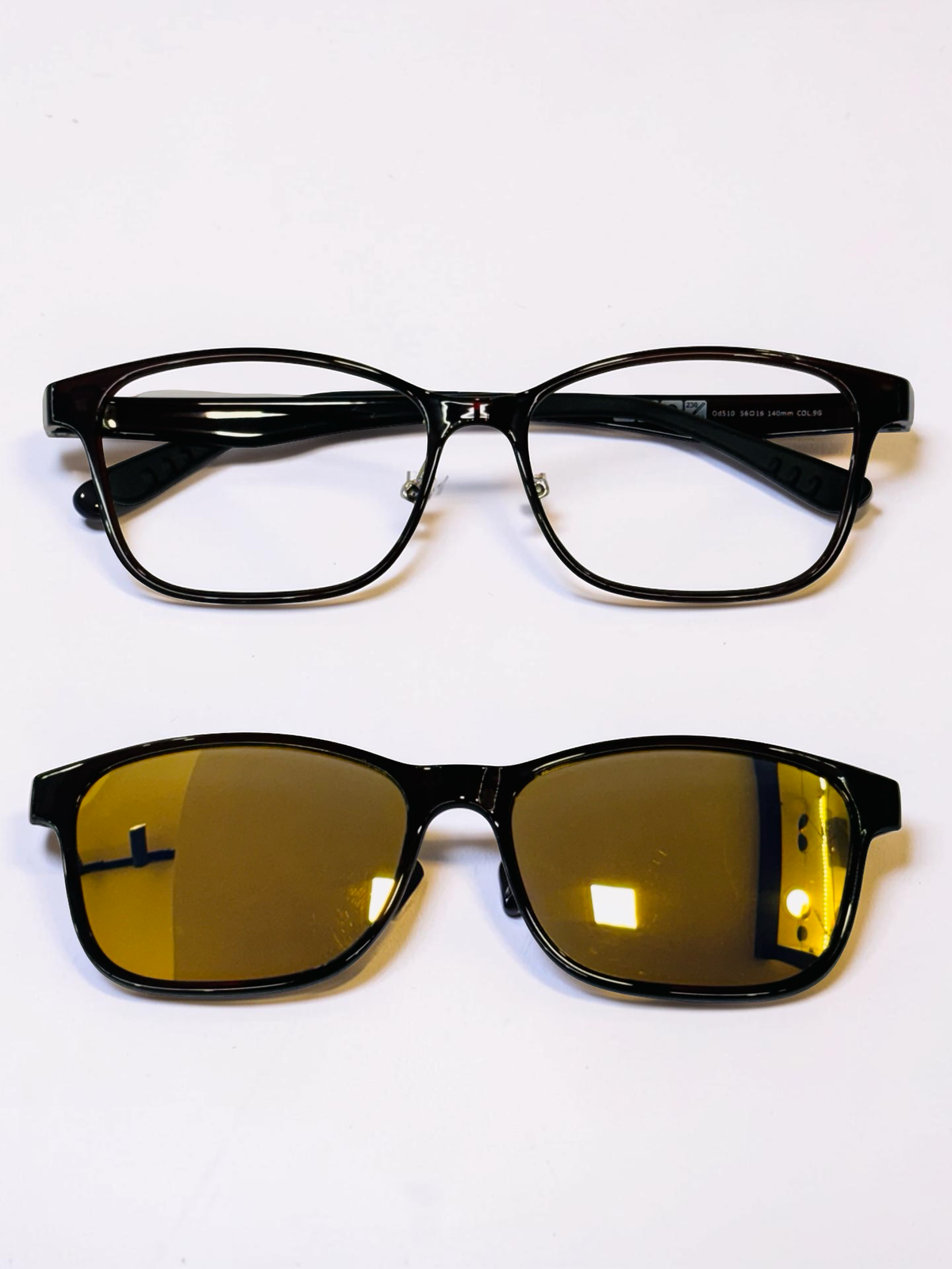 Black rectangular optical frame with yellow-tinted clip-on attached
